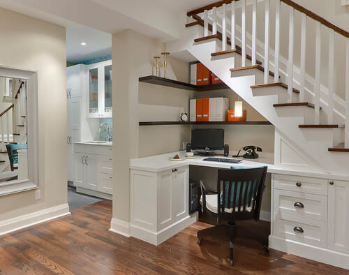 Photo by Leslie Goodwin Photography featuring an under the stairs office desk built-in.