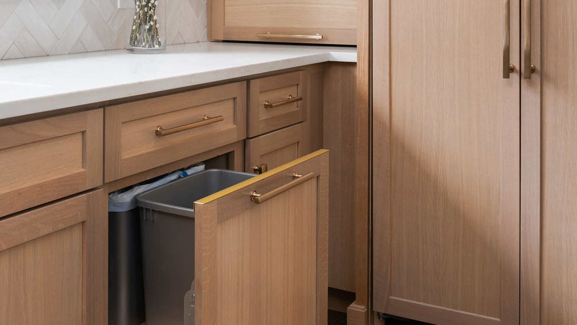 A m-out cabinet with two trash bins for waste and recylcing. Kitchen Cabinets and Storage from Dura Supreme Cabiinetry.