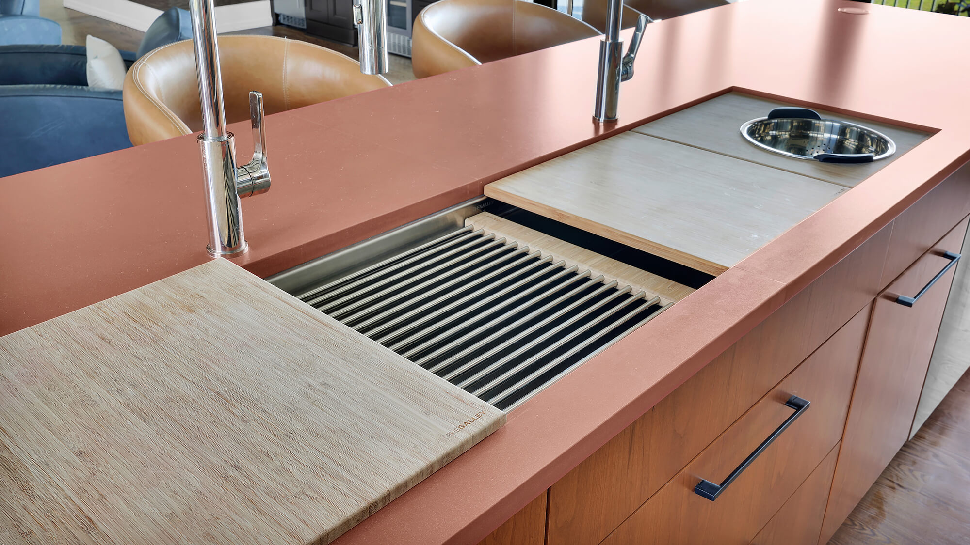 Workstation sink with a copper countertop creates a highly efficient kitchen prep zone for rinsing, chopping, straining, and food preparation. Warm wood slab cabinets and integrated sink accessories maximize workflow while preserving valuable countertop space.