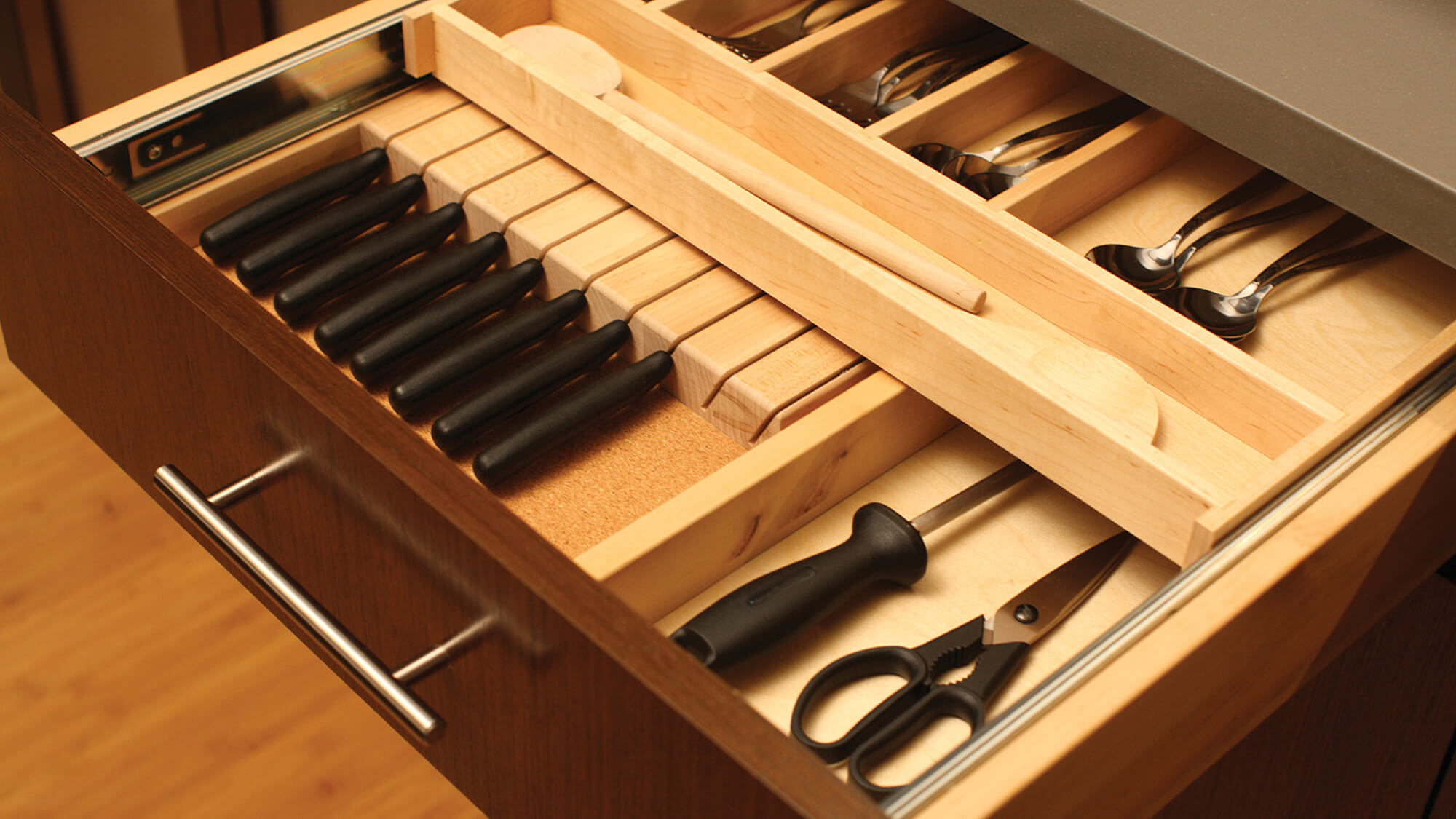 A two-tier slotted knife block tray and knife holder creates organized silverware and cutlery storage inside a kitchen cabinet drawer.
