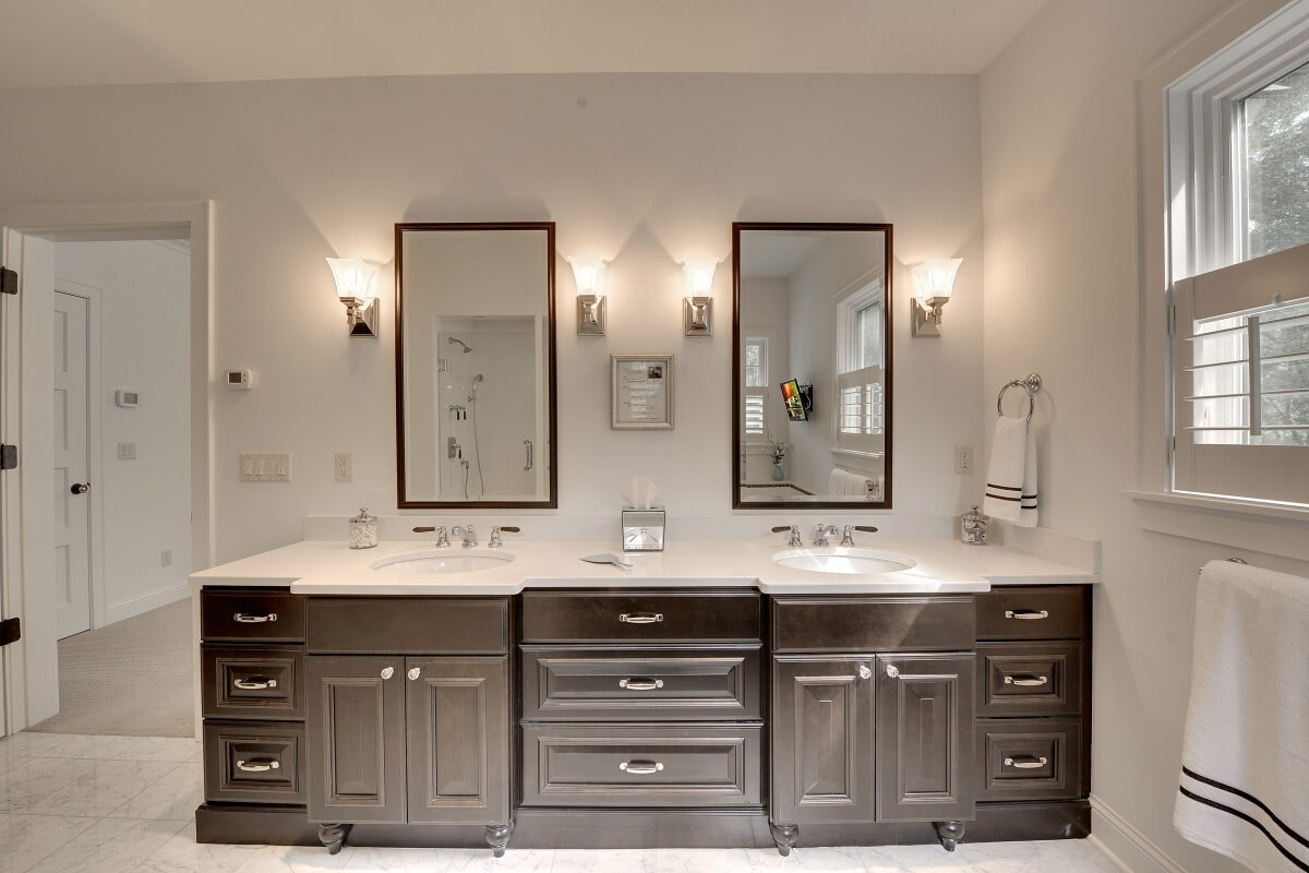 This bathroom design by Kristen Peck of Knight Construction Design, Inc. in Chanhassen, MN features the ideal distance between two lavatory sinks. The center drawer bank not only provides storage but extra space between the two lavatories.