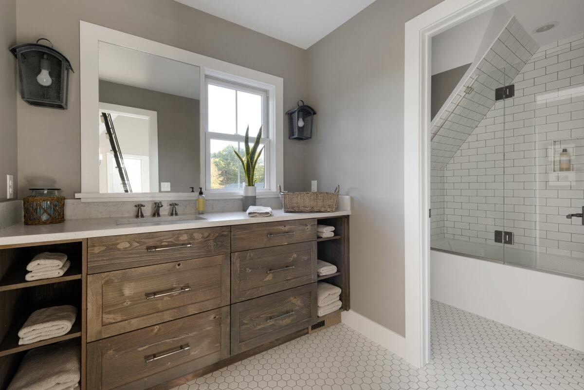 This charming bathroom is a great example of a single lavatory vanity that follows the suggested NKBA Lavatory Placement Guideline. Designed by Studio M Kitchen & Bath, Plymouth, MN and photographed by Spacefrafting Photography.
