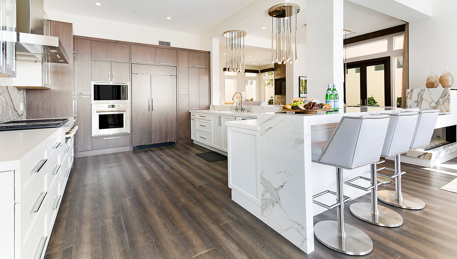 A massive kitchen island peninsula with seat for 8 to 10 people that has an L-shape.