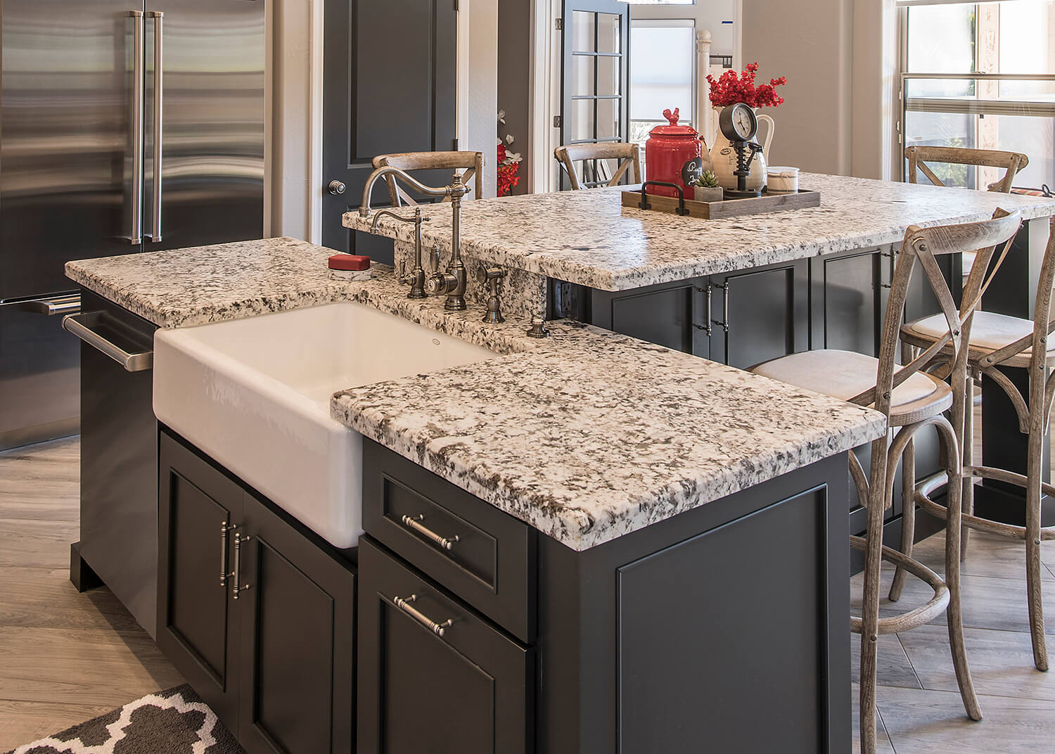 The seat height at this kitchen island uses bar height stools. The bar height counter helps separate the sink area from the dining area to prevent seated guests from any splashes from the sink.