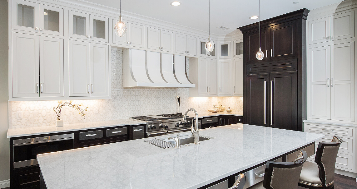 A black and white kitchen design with a hidden appliance panel fridge. This design features high contrasting two-toned Dura Supreme kitchen cabinets.