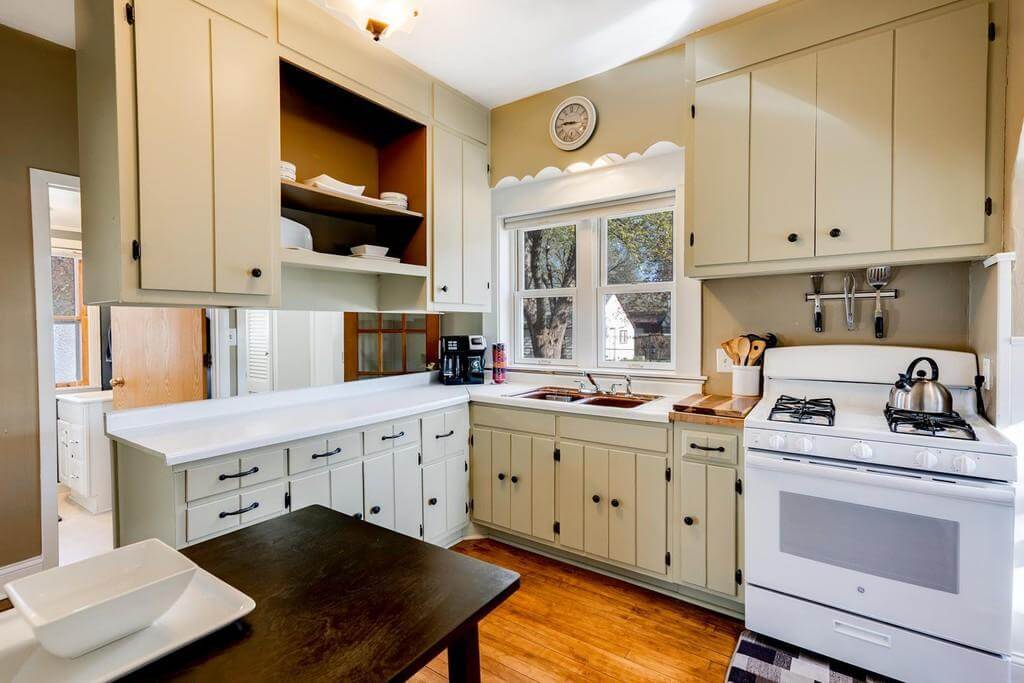 An old-fashioned kitchen design with a peninsula with ceiling hung upper cabinets.