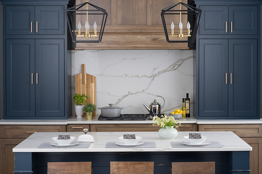 This fabulous modern famrhouse kitchen uses dark blue painted wall cabinets with inset doors contrasted with full overlay hickory cabinets used for the bases and modern wood hood. Crestwood cabinetry by Dura Supreme is a semi-custom and custom premium cabinetry brand made to fit your budget.