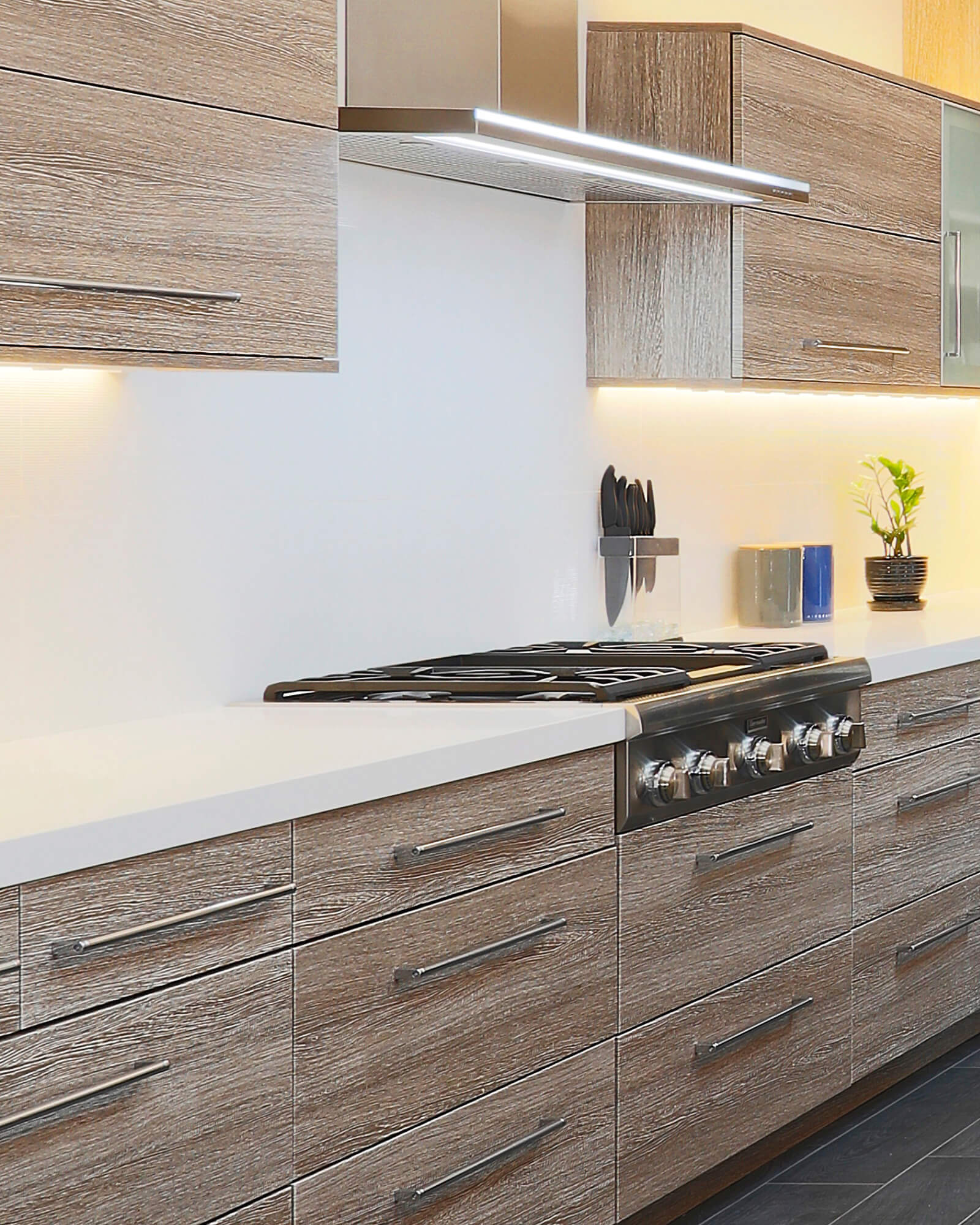Tempo-Horizontal custom kitchen cabinets in Vail Textured TFL showcase a dramatic horizontal grain pattern inspired by reclaimed wood. The modern slab door design, weathered wood character, and clean architectural lines create a warm contemporary kitchen with industrial-inspired appeal.