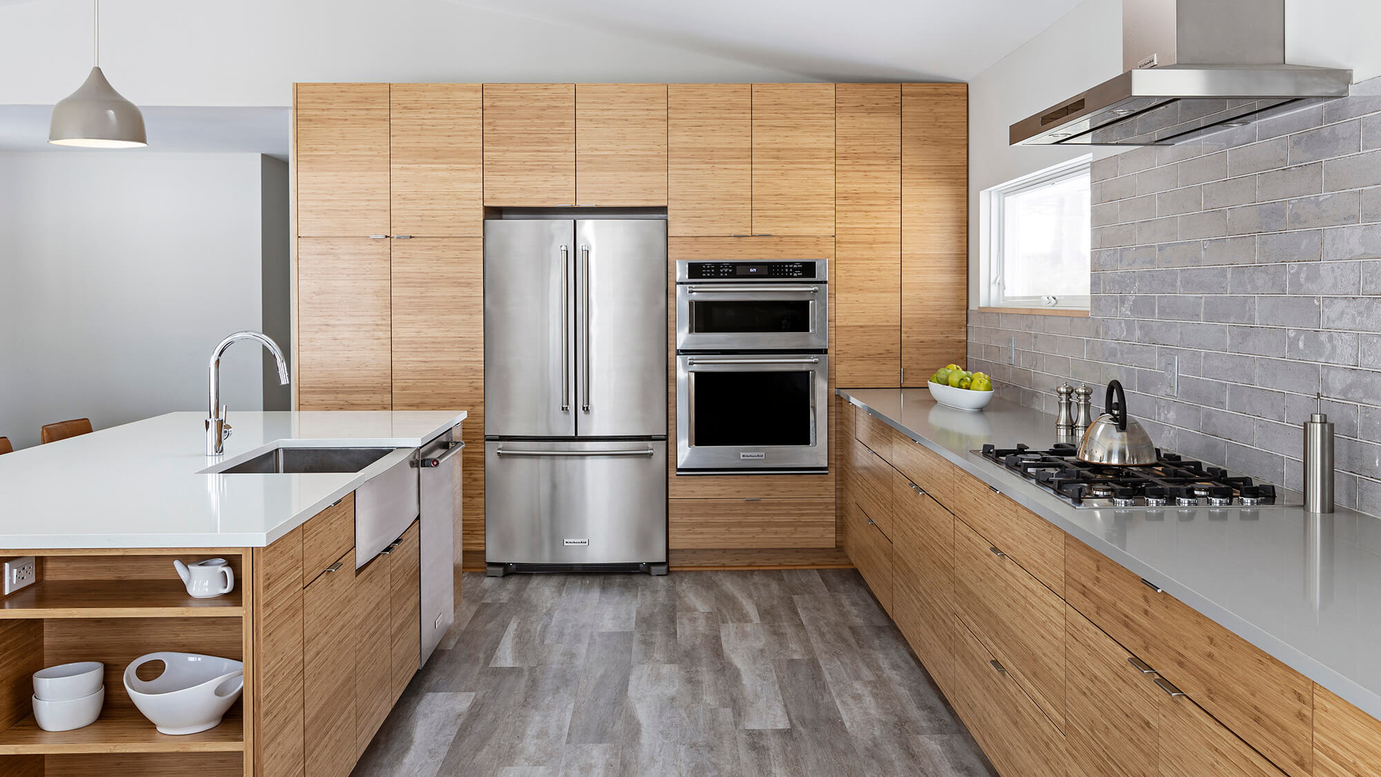 Horizontal grain natural bamboo kitchen cabinets create a striking contemporary look with streamlined slab doors and rich organic texture. Clean architectural lines, sleek metal fixtures, and modern cabinetry design emphasize the warmth and character of the bamboo grain.