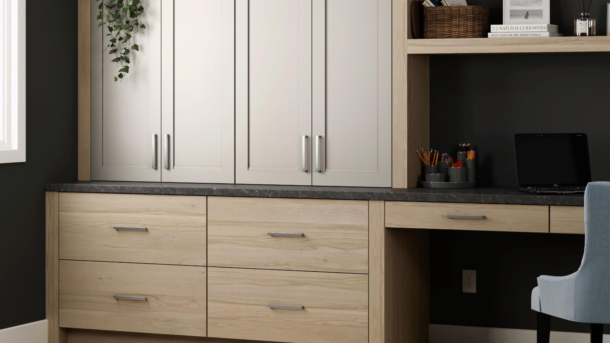 These built-in office cabinets blend soft painted cabinetry with light wood, horizontal grain base cabinets and desk for a warm, modern look. Open shelves, vertical storage, and understated cabinet hardware provide organization while maintaining a clean aesthetic.