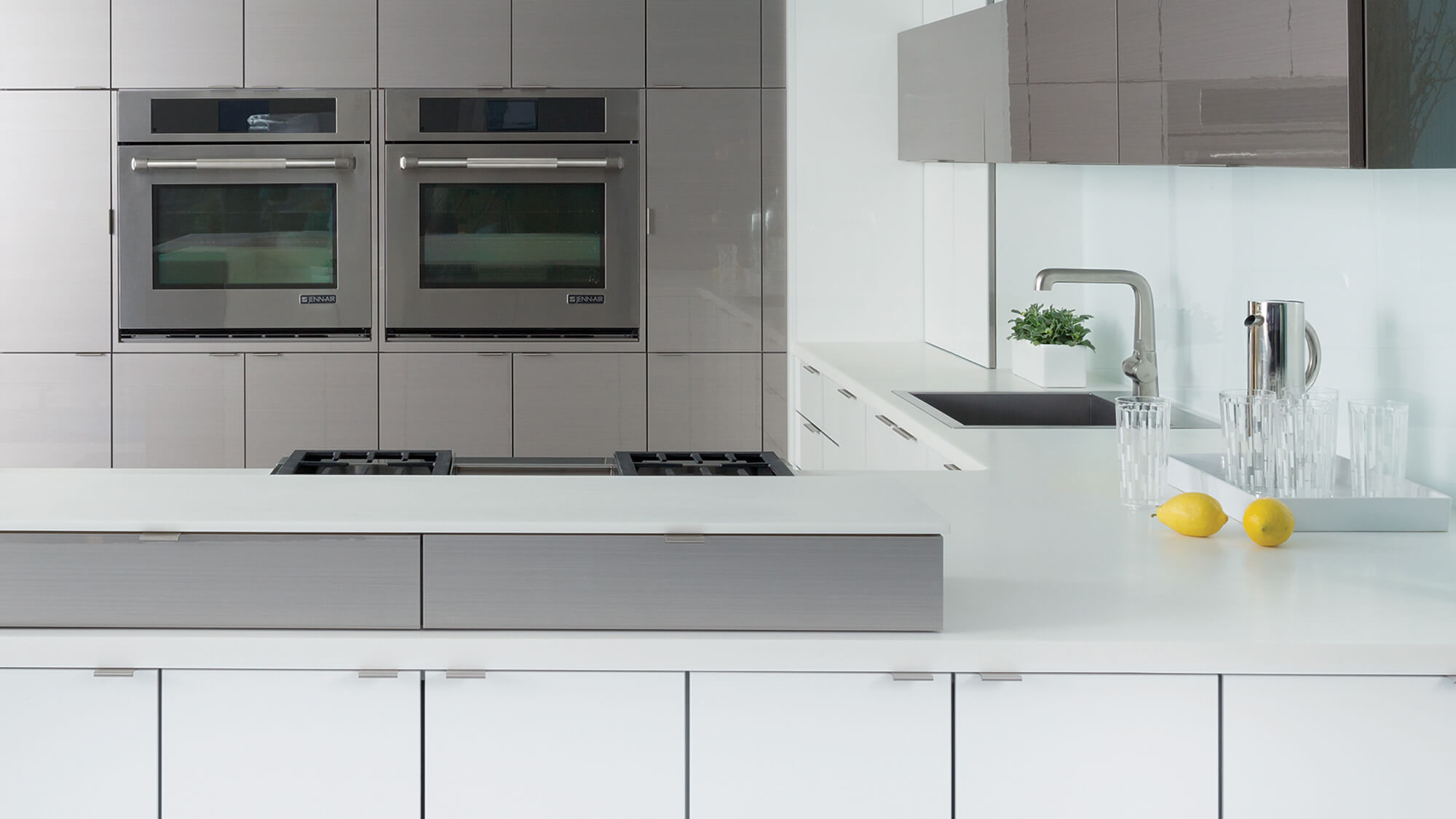 These ultra contemporary two-tone custom kitchen cabinets pair glossy solid white acrylic cabinetry with glossy horizontal grain wood-look cabinets featuring a metallic-inspired finish. Sleek slab doors, minimalist styling, and reflective surfaces create a sophisticated modern kitchen design.