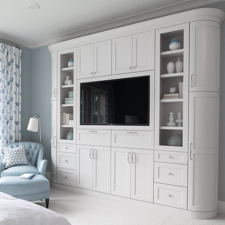 Four ways the pandemic has changed interior design trends. A master bedroom with a luxury built-in entertainment center and bedroom cabinets. The ends of the unit feature curved cabinet doors.