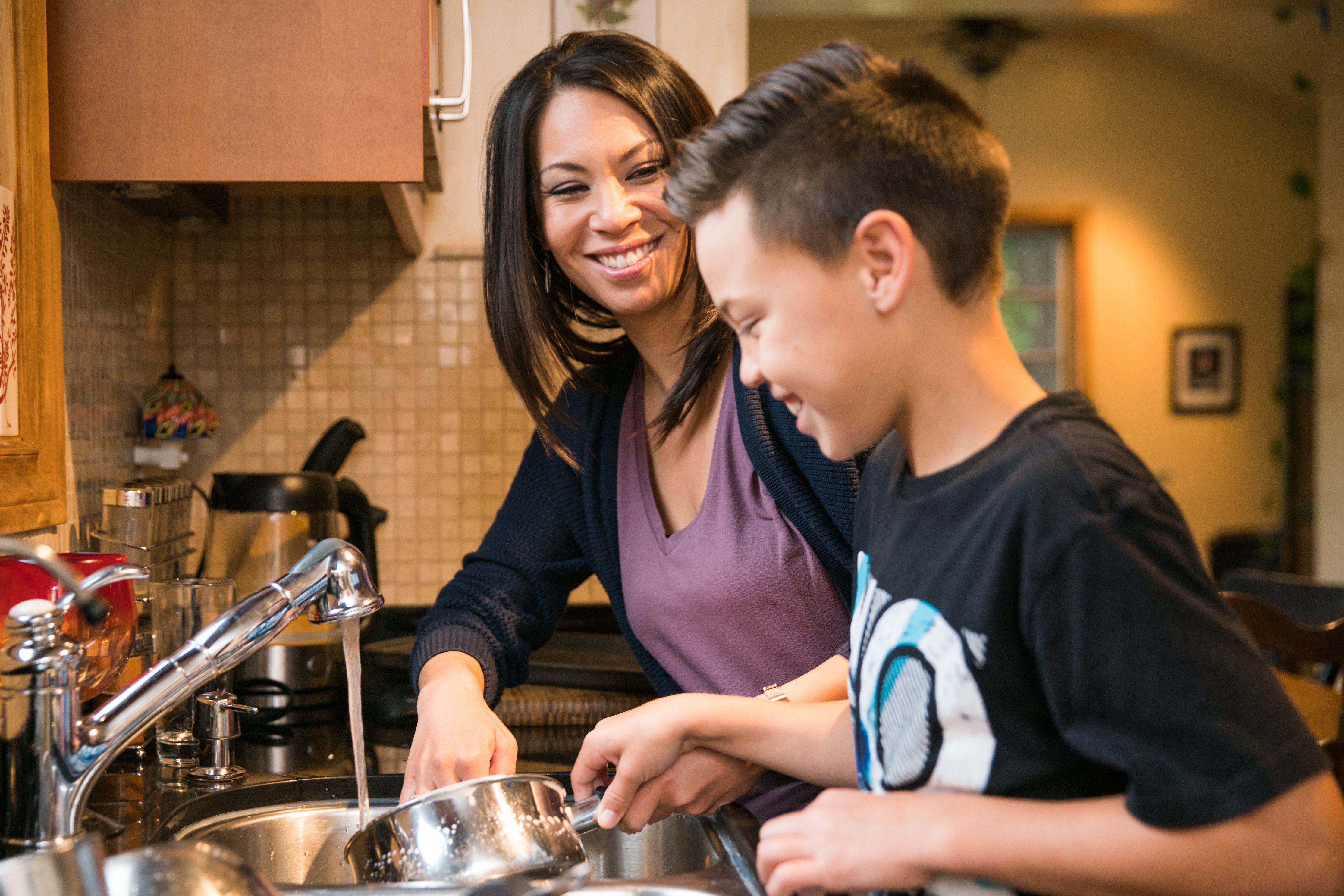 Your needs matter most during a kitchen remodel. Remember your priorities to design a layout that will work best. This mother and son are washing dishes togather and enjoying time together as a family in their newly remodeled kitchen.