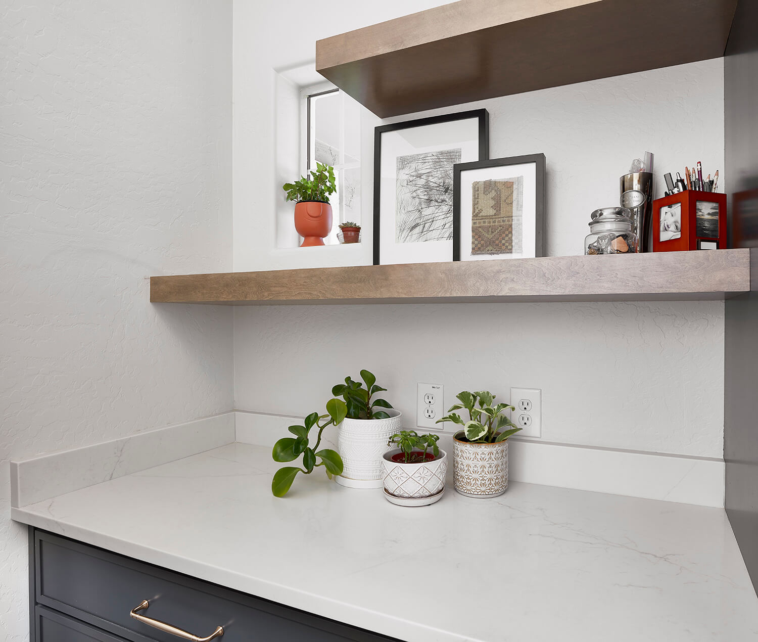 A small laundry room with dark charcoal gray cabinets with a skinny shaker door style and floating shelves.