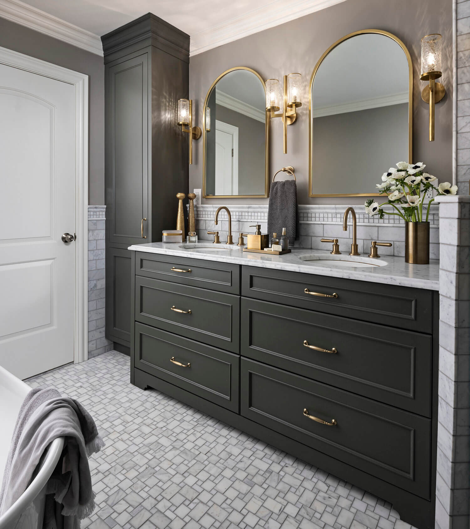 A trendy bathroom remodel with a popular dark green painted finish for the bathroom vanity and tall linen cabinet.