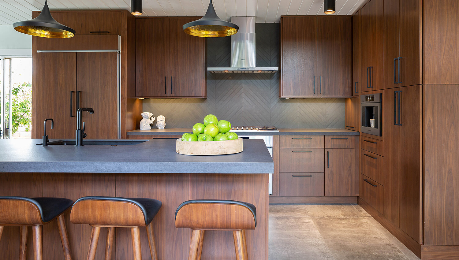 A dark wood kitchen with a mid-century modern look featuring a sleek, slab cabinet door style in Walnut.