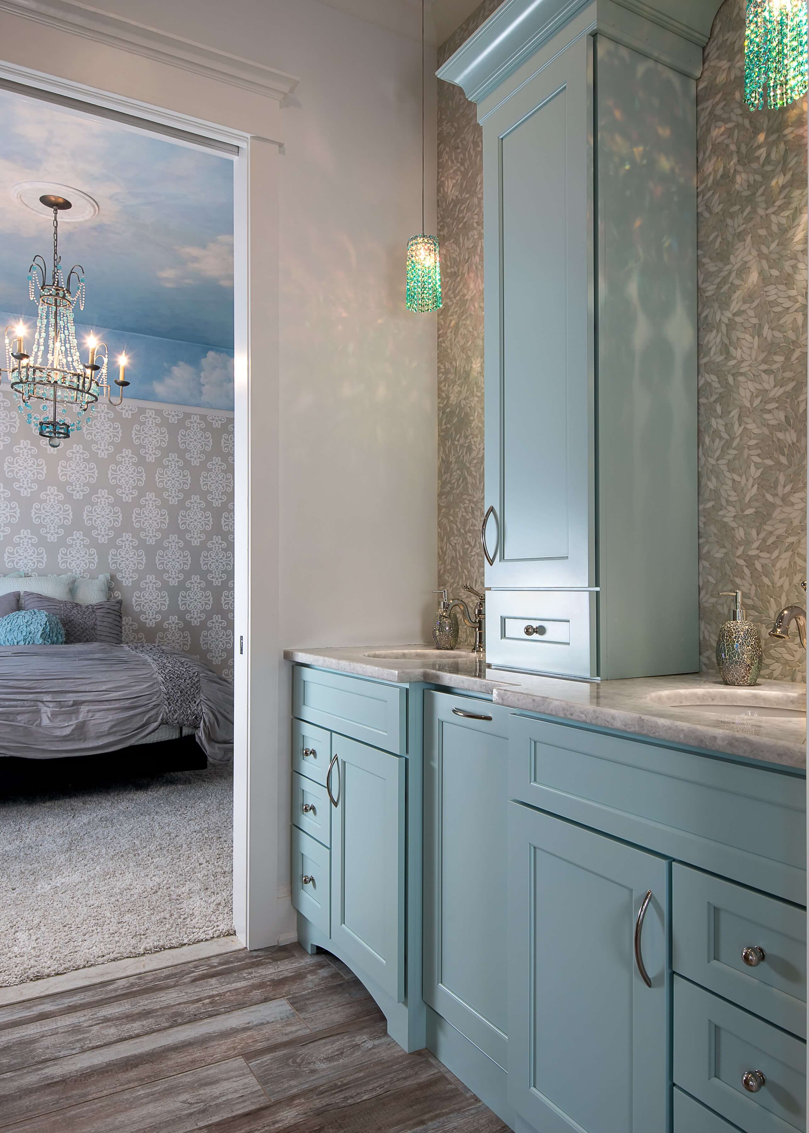 A dreamy blue bathroom with a sky blue custom painted vanity with a tall tower between the two sinks.