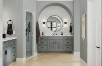 A boho inspired master bathroom design with a gray painted furniture style vanity with reeded cabinet door accents.