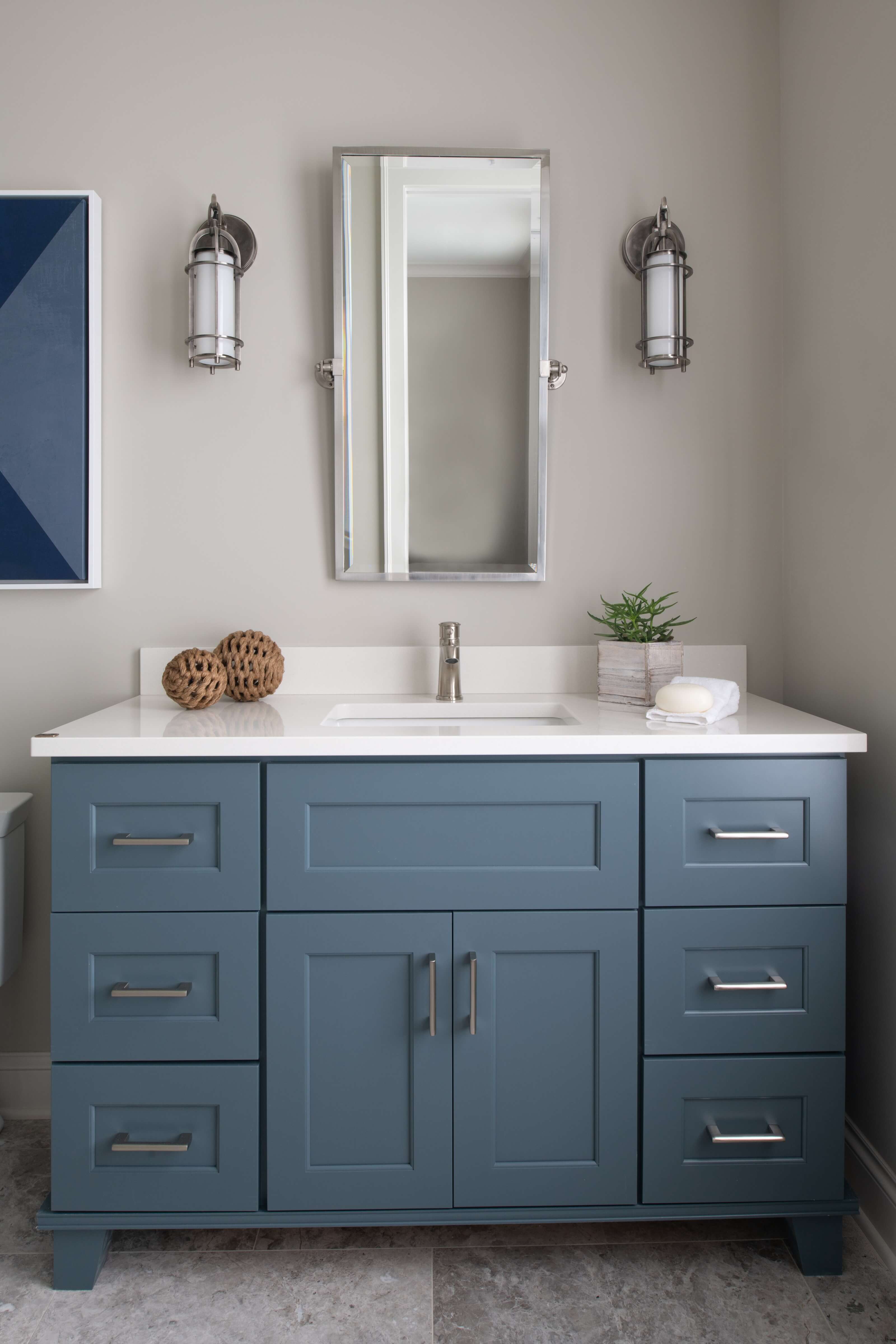 A colorful navy blue bathroom vanity with sleek bun feet that create a furniture look.