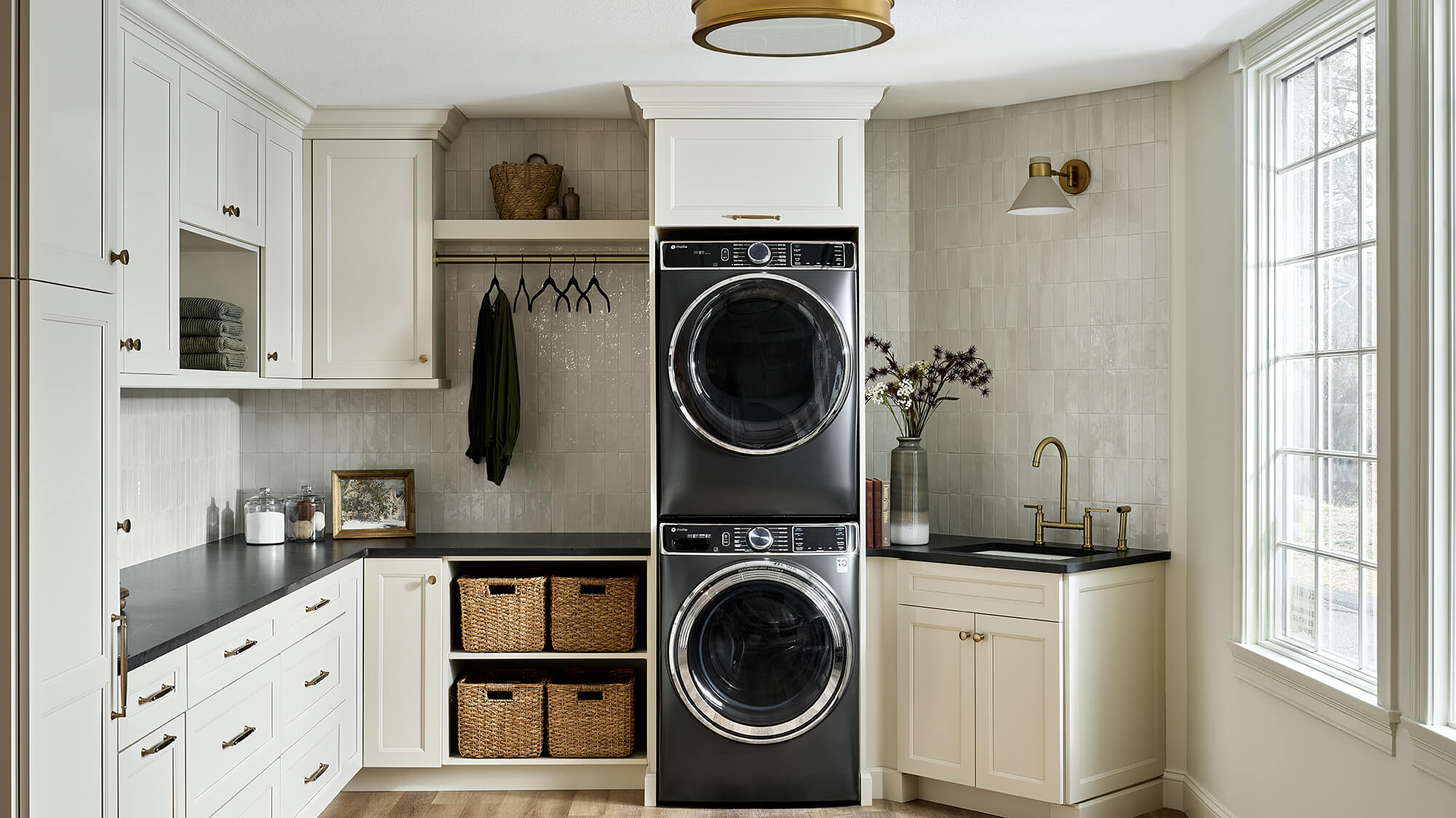 A chic laundry room design with muted white painted cabinets featuring Dura Supreme's unique Meridien door style.