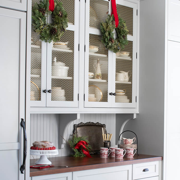 A holiday themed kitchen with wire mesh cabinet doors.