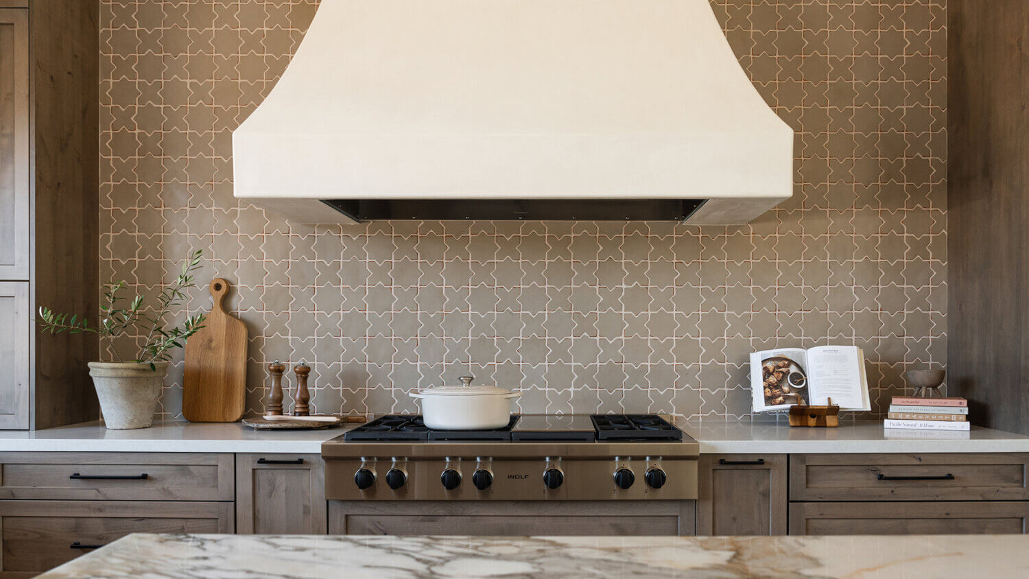 With an emphasis on comfort, heritage-inspired details, and lived-in textures, this family home is a Mediterranean oasis. This stunning Mediterranean inspired home features Dura Supreme’s Hudson shaker door style in a combination of the “Cashew” stain on Knotty Alder
