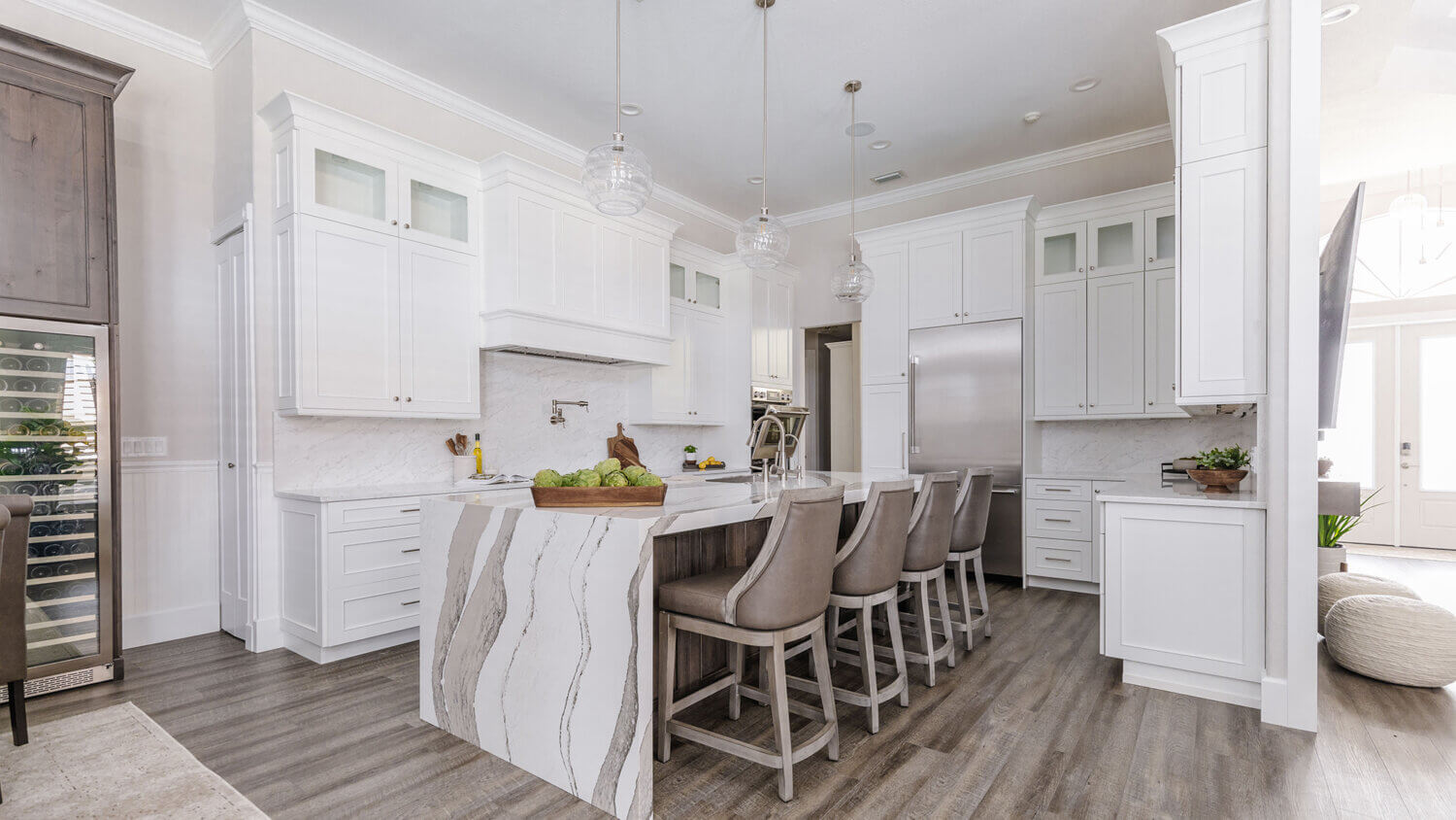 A luxurious kitchen design with white painted cabinets and a knotty alder kitchen island with a waterfall countertop.