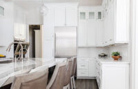 A classic kitchen design with white painted kitchen cabinetry and a large knotty alder kitchen island.