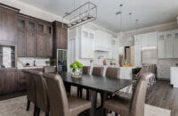 A view from the dining room showing the beverage center wall in knotty alder cabinets in the dining room contrasting the white painted cabinets in the kitchen.