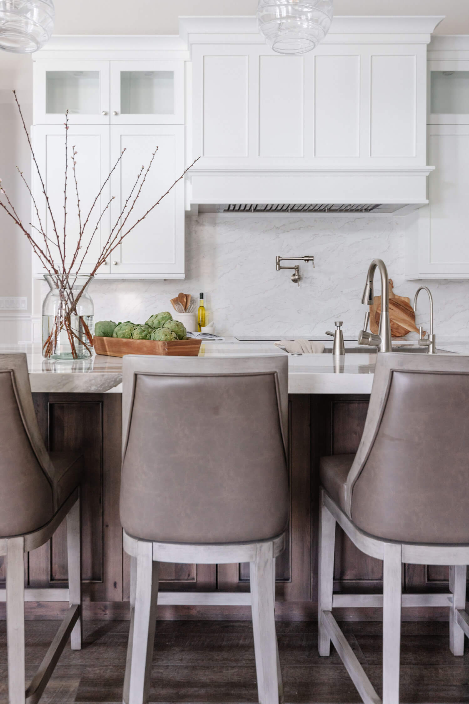An elegant kitchen design with a combination of white painted cabinets and dark stained knotty alder cabinets.