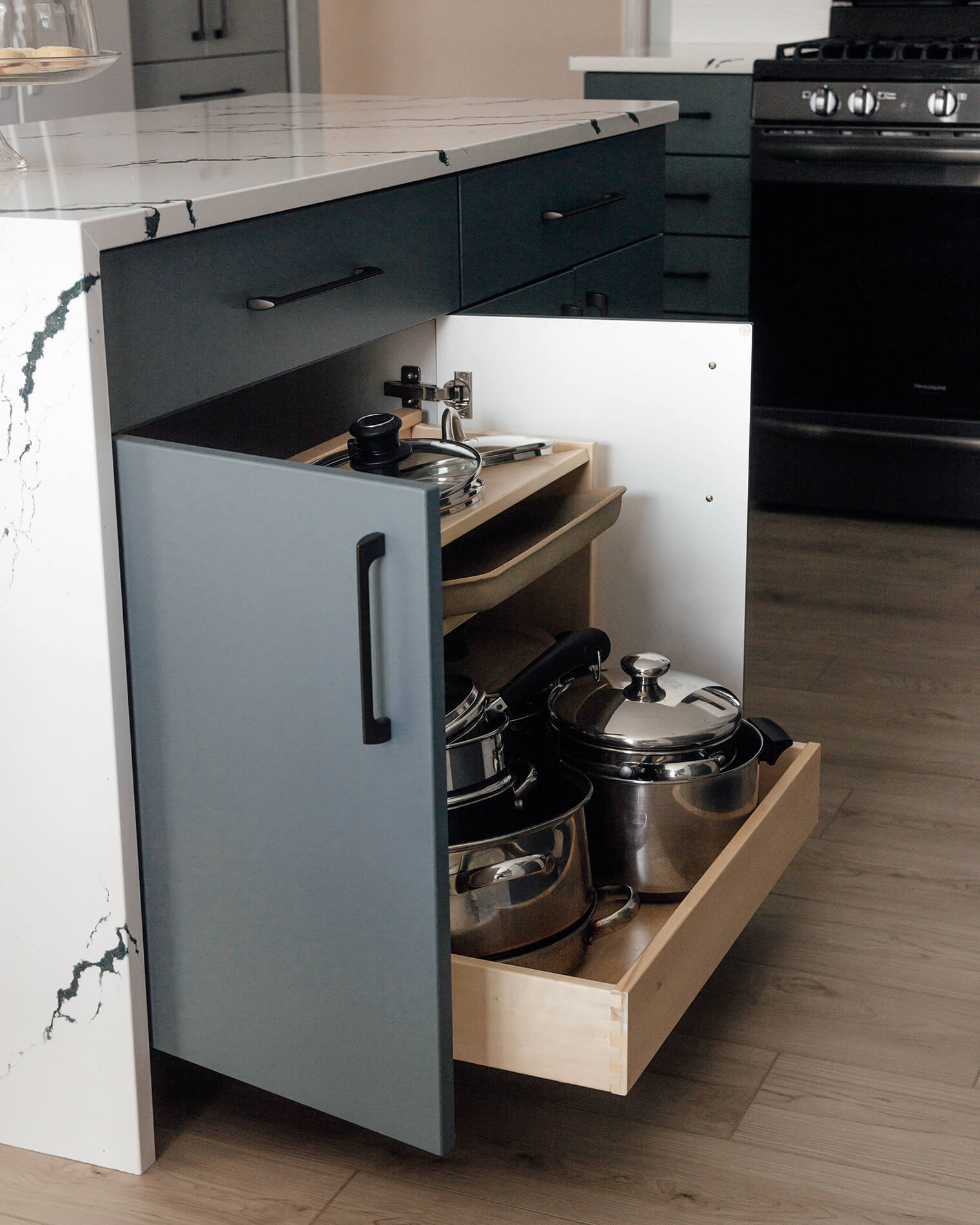 An entire cookware collection can be organized neatly in this single pull-out that houses pots and pans in the lower section and organizes lids above.